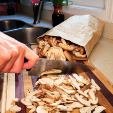 Load image into Gallery viewer, Fresh shiitake mushrooms being sliced on cutting board in kitchen

